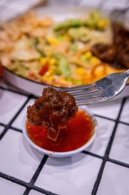 Çağdaş bir arkaplana karşı tatlı acı biber sosuna batırılan lezzetli ve lezzetli bir et..