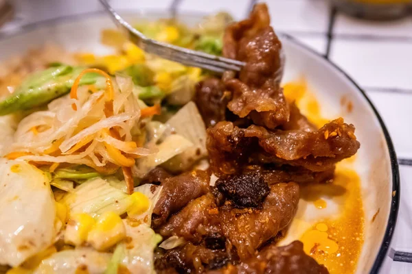 Bir çatalın Macro görüntüsü. Bol sos ve baharatla kaplı lezzetli bir parça et alıyor..