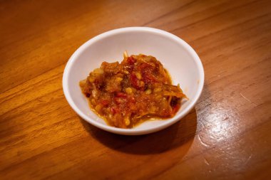 Endonezya Baharatlı Sambal Torbası ya da Küçük Beyaz Kâse 'deki Biber Ezmesi Tahta Masa