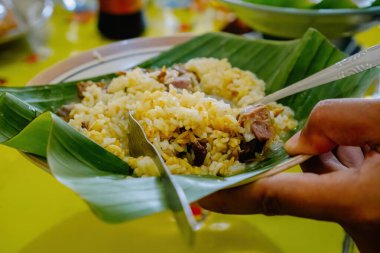 Otantik Nasi Gandul Pati 'den tipik yiyecekler Muz Yaprakları ve Et ve Salça ile servis edilir