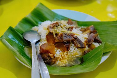 Otantik Nasi Gandul Pati 'den tipik yiyecekler Muz Yaprakları ve Et ve Salça ile servis edilir