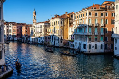 Venedik, İtalya - 13 Ekim 2025 Venedik 'te ünlü gondol ve Rialto Köprüsü ile ünlü Canal Grande' nin panoramik manzarası.