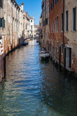 Venedik, İtalya - 13 Ekim 2025 Venedikli gondolcu Venedik 'in yeşil kanal sularında gondola biniyor.