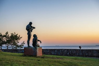 Prora, Almanya - 1 Kasım 2025: Havluyla ayakta duran çıplak adamın bronz heykeli ve Alman Prora kentindeki Baltık Denizi sahilinde Jrgen Raue 'nun 