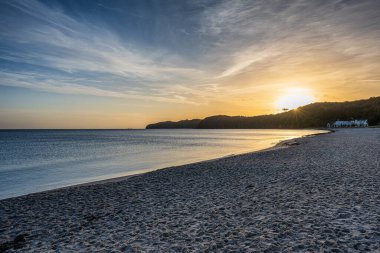 Almanya 'nın Rgen Adası' ndaki Binz Körfezi 'nde gün doğumu. İlk ışık Baltık Denizi' ni ve kumlu sahili yansıtıyor ve huzurlu bir sahil manzarası yaratıyor..
