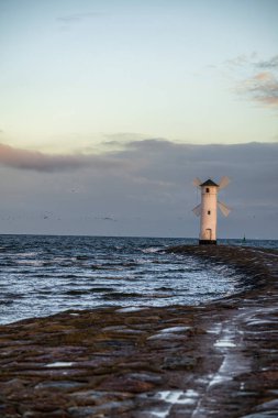 Polonya, Winoujcie 'deki Stawa Myny deniz feneri, Baltık Denizi kıyısında. Gün doğumunda değirmen şeklinde bir deniz feneri..