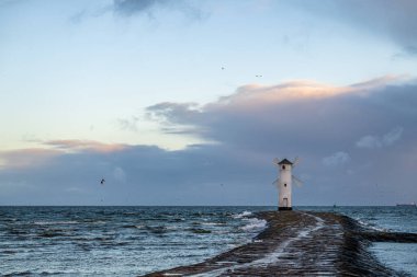 Baltık Denizi ve Stawa Mlyny, güneş doğarken rüzgar gülü şeklinde seyrüsefer feneri, Polonya 'nın Swinoujscie kentinin resmi sembolü.
