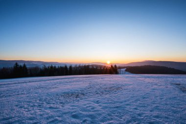 Renkli gündoğumunda kırsal kışın manzarası.