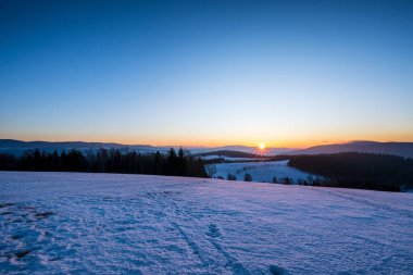 Renkli gündoğumunda kırsal kışın manzarası.