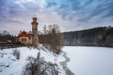 Neo-gotik kuleleri olan tarihi taş baraj Les Kralovstvi ve kışın kar manzaralı geçit.