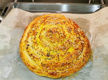 Üçüncü adım. Ispanaklı ve ricotta peynirli Burek. Peynirli yuvarlak turta, otlar, sarısı yağlı, susam tohumları serpiştirilmiş. Lezzetli Balkan turtası Borek. Vejetaryen yemekleri..