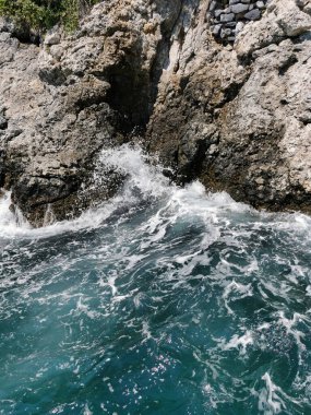 Türkiye 'nin Kusadasi kentinde gök mavisi deniz dalgaları kayalara çarptı