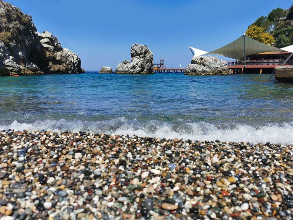 View of the pebble beach and the sea with rocks. the Aegean sea. Turkey, Kusadasi