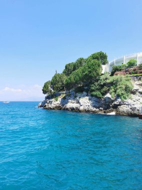 Ege Denizi manzarası ve yeşilliği olan kayalık bir sahil. Kusadasi, Türkiye.