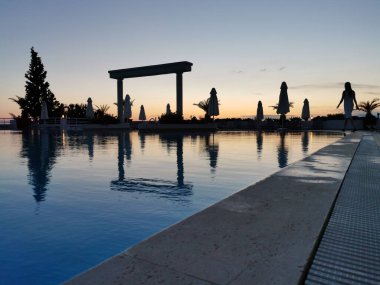 Boş havuz ve denizin üzerinde güzel bir gün batımı. Ege Denizi. Türkiye, Kusadasi
