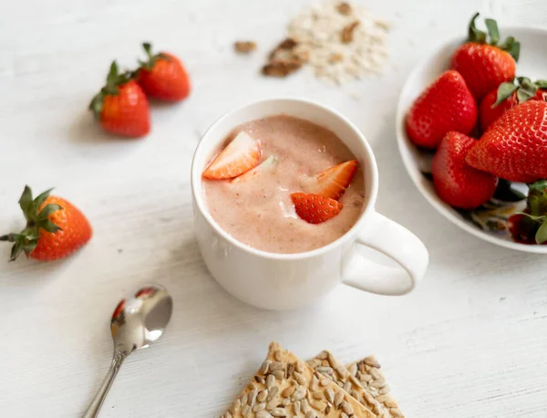 草莓冰沙 草莓在一个白色的木制桌子上的白色杯子 装饰有草莓 鸡尾酒杯旁边的饼干 健康与素食早餐概念 — 图库照片