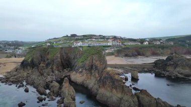Hope Cove, South Hams, Devon, İngiltere: DRONE VİEWS: Engebeli uçurumlar, sahil ve deniz manzaralı mülkler dahil Hope Cove. Devon, güzel kıyı şeridi ve kırsal kesimiyle tanınan popüler bir İngiliz turizm merkezidir (Clip 11).).