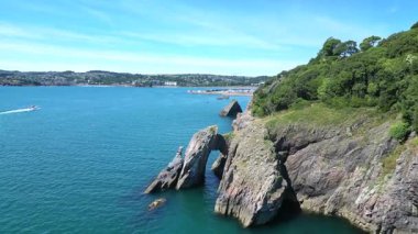 Torquay, Torbay, Devon, İngiltere: DRONE VİEWS: İnsansız hava aracı doğal kıyı şeridi üzerinde uçuyor, Londra Kemeri, ve Torquay ve marinasına doğru. Torbay, güzel kıyı şeridiyle ünlü popüler bir İngiliz tatil beldesidir..