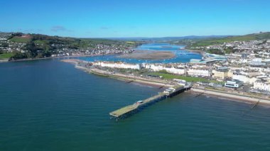 Teignmouth, Güney Devon, İngiltere: İHA arka planda Teign Nehri 'ni gösteren Grand Pier etrafında döner. Teignmouth, Birleşik Krallık 'ta popüler bir tatil beldesidir.).