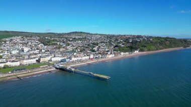 Teignmouth, Güney Devon, İngiltere: İHA arka planda Teign Nehri 'ni gösteren Grand Pier etrafında döner. Teignmouth, Birleşik Krallık 'ta popüler bir tatil beldesidir.).