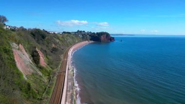 Teignmouth, Güney Devon, İngiltere: DRONE VİEWS: İHA kıyı şeridi boyunca uçar ve Teignmouth 'tan doğuya doğru giden tren yolu. Teignmouth İngiltere 'de popüler bir tatil merkezidir (1 / 2.)