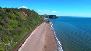 Teignmouth, Devon, İngiltere: Drone, Teignmouth yakınlarındaki Sprey Point 'te kumlu sahil ve demiryolu boyunca doğuya doğru uçuyor. Teignmouth İngiltere 'de popüler bir tatil beldesi ve limanıdır..