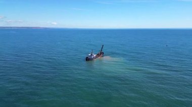Teignmouth, Güney Devon, İngiltere: DRONE VİEWS: Teign Nehri 'ne yakın bir tarama alüvyonu; tarama, Teignmouth limanına nakliyenin engelsiz geçişini güvence altına alır. Teignmouth aynı zamanda popüler bir İngiliz turizm merkezidir (Klip 1 / 3).