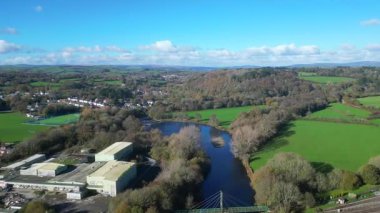 Totnes, Devon, İngiltere: DRONE VİEWS: Nehir Dart üzerinde bir demiryolu köprüsü, sağda Güney Devon buharlı tren istasyonu ve solda bir sanayi bölgesi. Totnes, alternatif yaşam tarzıyla daha çok tanınan bir pazar kasabası..