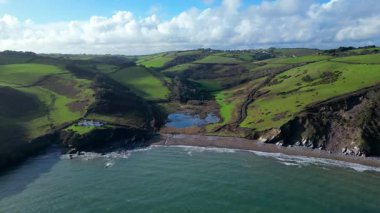 Man Sands, Güney Devon, İngiltere: Man Sands plajı Brixham 'ın yaklaşık 1,5 mil güneyindedir ve aylaklar, kaya havuzcuları, kanocular ve rüzgar sörfçüleri arasında popülerdir. Kumsalın arkasındaki göl kuşlar ve çim yılanları için bir sığınaktır..