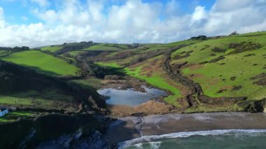 Man Sands, Güney Devon, İngiltere: Man Sands plajı Brixham 'ın yaklaşık 1,5 mil güneyindedir ve aylaklar, kaya havuzcuları, kanocular ve rüzgar sörfçüleri arasında popülerdir. Kumsalın arkasındaki göl kuşlar ve çim yılanları için bir sığınaktır..