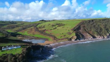 Man Sands, Güney Devon, İngiltere: Man Sands plajı Brixham 'ın yaklaşık 1,5 mil güneyindedir ve aylaklar, kaya havuzcuları, kanocular ve rüzgar sörfçüleri arasında popülerdir. Kumsalın arkasındaki göl kuşlar ve çim yılanları için bir sığınaktır..