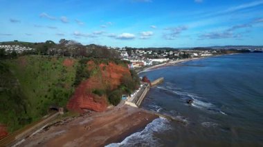 Dawlish, Güney Devon, İngiltere: Drone ana hat demiryolu hattı üzerinden yükselir, bir demiryolu tüneli ve kızıl kumtaşı uçurumları Dawlish 'in bir kasabasını ortaya çıkarır. Dawlish, siyah kuğularıyla ünlü popüler bir İngiltere tatil beldesi..