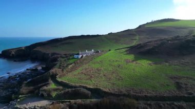 Man Sands, Güney Devon, İngiltere: DRONE VİEWS: Sahil, lagün ve yakındaki teraslı kulübeler. Man Sands plajının arkasındaki göl kuşlar ve çim yılanları için bir sığınaktır; bölgenin kendisi başıboşlar, kanocular ve rüzgar sörfçüleri tarafından popülerdir..