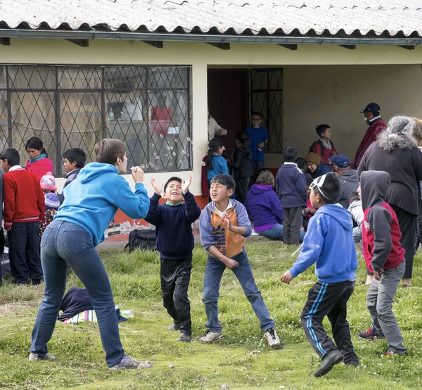 June 14, 2016-Riobamba, Ecuador: Traveler plays with local children — Stock Photo, Image