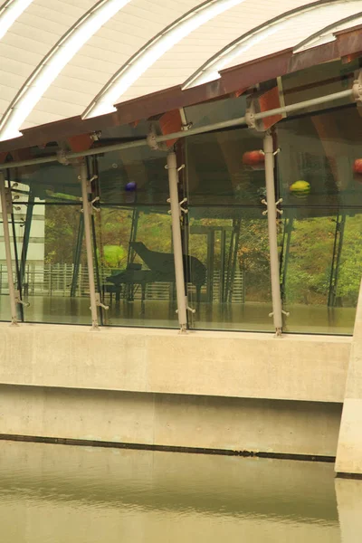 Arkansas, Bentonville 'deki Crystal Bridges Müzesi' nin geniş pencerelerinden görülen boş bir salonda büyük bir piyano görüldü..