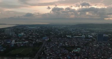 Kalabalık sokakları ve meskenleri olan Davao City. Mindanao, Filipinler. Şehir: Bulutlu gün batımı ile şehir ve alacakaranlık.
