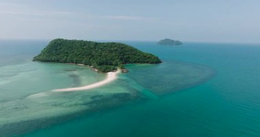 Turkuaz sularla çevrili yemyeşil bir ada. Parlak güneşli bir gökyüzünün altında beyaz bir kumsal var. Ko Pha Ngan, Tayland.