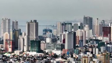 Makati 'deki iş yeri binaları ve yüksek binalar. Mavi gökyüzü ve bulutlar. Metro Manila, Filipinler.