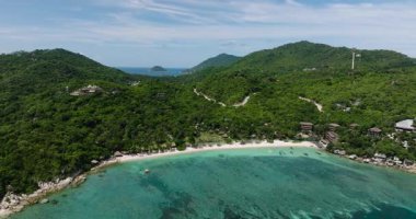 Zümrüt yeşili sular yoğun orman tepeleri ve dağınık sahil tatil beldeleri olan tropikal bir kıyı şeridiyle karşılaşır. Köpekbalığı Körfezi. Koh Tao, Tayland.