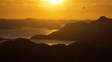 Adaların üzerinde turuncu gökyüzü. Filipinlerde Günbatımı.