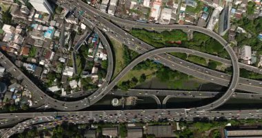 Çevresi yeşilliklerle çevrili canlı şehir ortamında araçları olan yoğun bir yol ağı. Bangkok, Tayland.