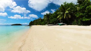 Hindistan cevizi ağaçları, kumdaki tekneler ve Tiamban Sahili 'ndeki temiz su. Romblon Adası. Filipinler.