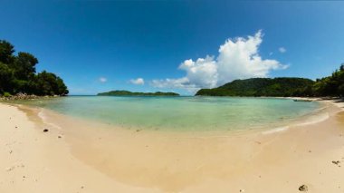 Kıyı şeridinde tekneleri olan bir ada. Mavi gökyüzü ve bulutlar. El Nido. Palawan 'da. Filipinler.