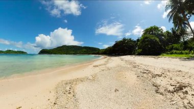 Şeffaf deniz suyu ve dalgaları olan tropik bir sahil. Mavi gökyüzü ve bulutlar. El Nido. Palawan 'da. Filipinler.