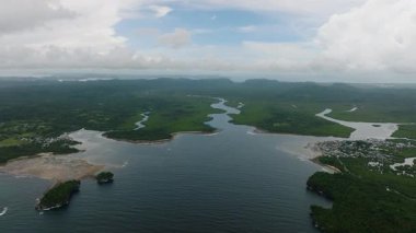 Nehir ağzı bir yerleşim yerine ulaşmadan önce mangrov ormanını kesiyor. Siargao, Filipinler.