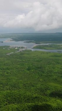 Mangrov nehirlerinin kıyıya yakın bir yerleşim bölgesinde denize dökülen insansız hava aracı görüntüsü. Siargao, Filipinler.