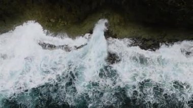 Dalgaların yukarıdan aşağıya doğru, orman kenarından kayalık kıyılara çarpması. Siargao, Filipinler.