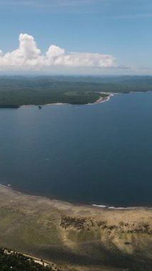 Uzun bir kıyı şeridi ve iç kısımlara uzanan yeşil tepeleri olan tropik geniş körfez. Siargao, Filipinler.
