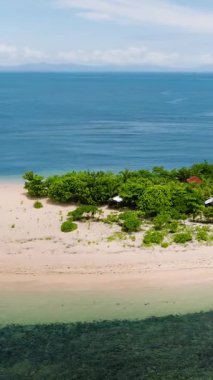Mavi denizle çevrili beyaz kum ve yemyeşil adanın havadan görünüşü. Siargao, Filipinler. Kangkangon Adası.