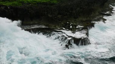 Ağır okyanus dalgaları ve beyaz köpüklü sahil uçurumu manzarası. Siargao, Filipinler. Yavaş Hareket.